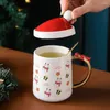 カップソーサークリスマスハットのふたとスプーンの手作りのファニーユニークな贈り物を添えたセラミックコーヒーマグ