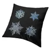 Oreiller joyeux Noël boîtier de flocon de neige décoratif quatre flocons de neige sur fond noir.