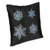 Oreiller joyeux Noël boîtier de flocon de neige décoratif quatre flocons de neige sur fond noir.