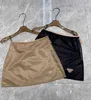 Skirts Designer Brand Triangle 2024 Printemps / été Nouveau bloc de couleur à la mode nylon A-Line demi-jupe haute taille enveloppée Hip Spicy Girl Short E5MU