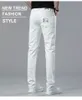 イタリアのハイエンドのトレンディなスリムフィットフィットホワイトジーンズは、トレンディな夏の薄いストレッチカジュアルパンツブラック、ホワイト、ブルーの小さな足の韓国語バージョンの男性のための白いジーンズ