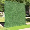 装飾的な花の布を裏打ちする緑の工夫草の生け垣の壁の背景とイベント退院