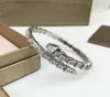 Najnowsza klasyczna bransoletka w kształcie węża w pełnym diamencie ma delikatne i czarujące różowe złoto i srebrne linie, ozdobione jasnymi diamentami
