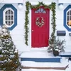 装飾的な花のクリスマスリース群れ雪霜の赤い松の円錐屋外の家の正面玄関屋外