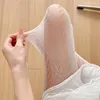 Женщины носки сексуально смотрит сквозь сетку сетку с тугим поломки бауни
