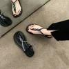 Sandales portant des chaussures romaines sur les pieds de clip à fond plat d'été extérieur avec une topon de chevrons à la jupe pour les femmes