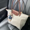 2024 Classic Tote Bag Versatile Folding Bag Womens Handväska Lång handtag en axel Dumpling Bag Pendil Bag 10a