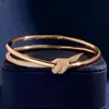 Mens Femmes en acier en acier en acier inoxydable Tirant en coeurs Style Double noeud Charms bracelets Bangles 18k Gold avec des sachets de bijoux