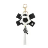 Ключевые кольца знаменитые бренд Keyring Black White Leather Camellia Camellia Camellia Camellia CwareChain Женские модные цветочные цепочки Llaveros Flore Bag Charms 240412