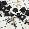 Ключевые кольца знаменитые бренд Keyring Black White Leather Camellia Camellia Camellia Camellia CwareChain Женские модные цветочные цепочки Llaveros Flore Bag Charms 240412