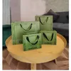 Enveloppe cadeau 500pcs / lot en gros logo personnalisé en papier imprimé en papier vert pour les vêtements d'affaires Boutique Bag OEM