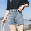 Les shorts en jean de taille de taille féminine ont déchiré l'ourlet cru jean décontracté l'été coupé dans la rue avec des poches 240407