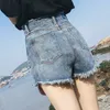 Les shorts en jean de taille de taille féminine ont déchiré l'ourlet cru jean décontracté l'été coupé dans la rue avec des poches 240407