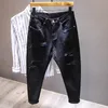 Vita jeans män all-match mode rippade hål smala stretch harem byxor bekväma manliga streetwear denim byxor 240412