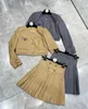 Tweedelige kledingontwerper Gloednieuwe PRA Elegante leeftijd Vermindering van woon -pendelende driehoek korte jas met hoge taille geplooide rok set 4u5y
