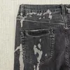 Jeans maschile viola nera fuoriuscita vernice candeggina a metà ascesa