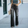 Fashionabla jeans kvinnors tvättade hål visar bantning vid benbyxor