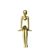 装飾的なフィギュア樹脂抽象物体彫像装飾品キャラクターアート座っている姿勢彫刻が飾る黄金のモダンな生活装飾
