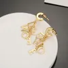 Site officiel du même style Loevwe des boucles d'oreilles de la lettre d'or de concepteur de luxe pour femmes, les détails sont traités très délicatement et en douceur