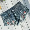 Kvinnors shorts Nya kvinnors sexiga knappar med låg rise jeans denim shorts ultrakort nattklubb lapptäcke shorts feminino y240425