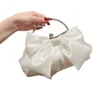Elegant White Satin Evening Bag: Perfekt för bröllop eller fester. Har ett charmigt båge- och metallhandtag. Shoppa nu!