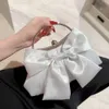 Elegant White Satin Evening Bag: Perfekt för bröllop eller fester. Har ett charmigt båge- och metallhandtag. Shoppa nu!