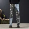 Jeans masculinos Splicing Camouflage mass de camuflagem com calça de bolsos cônicos gráficos Spring e outono da moda e outono Q240427