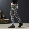 Jeans masculinos Splicing Camouflage mass de camuflagem com calça de bolsos cônicos gráficos Spring e outono da moda e outono Q240427