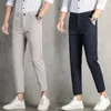 Primavera SUMPLEM SUMPLE ICE SILK Casual casual jovem mano de ajuste Slim Fit Pants Solid Button Bolsões de zíper versátil linear calças soltas 240424