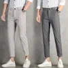 Primavera SUMPLEM SUMPLE ICE SILK Casual casual jovem mano de ajuste Slim Fit Pants Solid Button Bolsões de zíper versátil linear calças soltas 240424