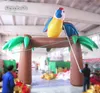 Arco di palme gonfiabile all'ingrosso 4m di larghezza 13 piedi Archway soffiato con un uccello pappagallo per la decorazione del parco a tema della giungla