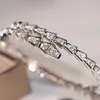 Diseñador Lin Zhou Pulsera de hueso de serpiente con diamantes llenos Chapado en oro de 18 quilates Pulsera abierta con diamantes de cabeza calva y cola de primavera Regalo de boda moderno y moderno