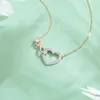 Дизайнер ювелирных украшений Swarovskis Ши Цзя 1 1 использует ожерелье с узлом в виде хрустального сердца и минималистскую цепочку на ключице в более дорогой версии