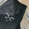 Mens Shorts Yaz Klasik Siyah Pamuk Gevşek Dantel Yukarı 5/4 Şort Yüksek Sokak Modaya Metal Üçgen Mektup Deri Etiket Mektubu İşlemeli Spor Pantolon Boyut