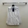 Blouses pour femmes Chemises de marque New Pra a un tempérament polyvalent et une taille fine avec un col en diamant pressé à chaud Chemise en popeline brodée RU2E