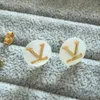 Orecchini a bottone di marca di lusso con conchiglia bianca Orecchini di design da donna semplici con lettera V in acciaio inossidabile all'ingrosso