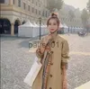 Women's Trench Coat Designer 2023 Trench Coat European och American Luxury Plaid Style Fashion Stitching Fake Two Loose Women's Mid-Längd YQ231025