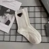 Chaussettes pour hommes Designer femmes chaussettes Triangle badge noir et blanc chaussettes hautes chaussettes de veau chaussettes de genou de mode Top qualité L230919