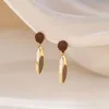 Nuovi accessori per le orecchie Orecchini lunghi con piume marroni dal design di nicchia. Gli orecchini sono regali di festa semplici, leggeri, lussuosi e suggestivi per le ragazze