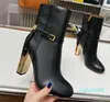 Black boots with cut-out detail and gold-coloured metal