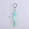 Porte-clés Design Silicone Porte-clés Couleur vive Perles de fleurs Bracelet Charme avec sac à pompon Pendentif Idées Cadeau pour elle 2023