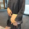 女性のセーターが倒れます