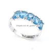 С боковыми камнями счастлившина прибытие Fl Oval Sky Blue Topaz Gemstone 925 стерлинговый стерлинг, покрытый женским шармом, подарки кольца Jewelr Dhla1