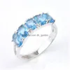 С боковыми камнями счастлившина прибытие Fl Oval Sky Blue Topaz Gemstone 925 стерлинговый стерлинг, покрытый женским шармом, подарки кольца Jewelr Dhla1