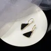 Charm earrings in black and white enamel finish. 18k gold-plated logo and frame, luxury earring designer for women. Brand fashion aretes. bridal engagement jewelry