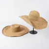 Il designer casual Rafia lavorato a mano all'uncinetto sovrasta i cappelli parasole da spiaggia all'aperto