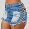 Kvinnors jeans 2023 Sommar mitten av midjan mini Tassels hål shorts kvinnor båda sidor binder kort sexig denim