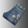 Primavera da marca Summer Summer Jeans Jeans Elastic Corean Version Slim Fitting Feet Horse Golden Print Blue Pants265g