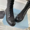 Garniture en cuir de veau noir patchwork bottes de combat hautes en nylon empeigne à lacets à hauteur du genou bout arrondi logo latéral plat triangle plaque designer de luxe pour femmes usine