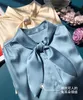 2023 Autumn Blue Solid Color Ribbon Tie Bow Silk Blus Shirt Lång ärm Runda nacke veckad enkelbröst Soie-toppskjortor H3G22Ted